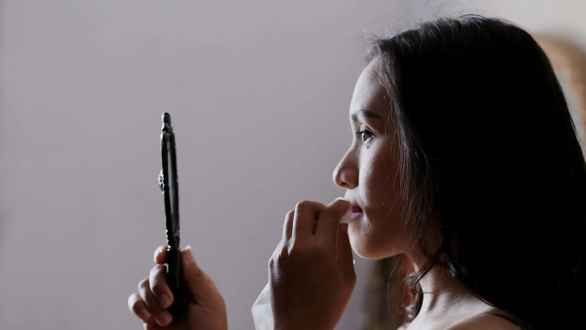 Woman examining her reflection in a mirror